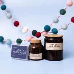 Pine, Berry, Moss, Raspberry, Musk, Evergreen, Spice

One of the three new scents this season, Son of a Nutcracker is a unique mix of earthy, sweet, and spicy notes. The pine and evergreen bring classic holiday vibes but the raspberry (and even cotton candy) notes bring a little surprise and fun.

- 7 ounces
